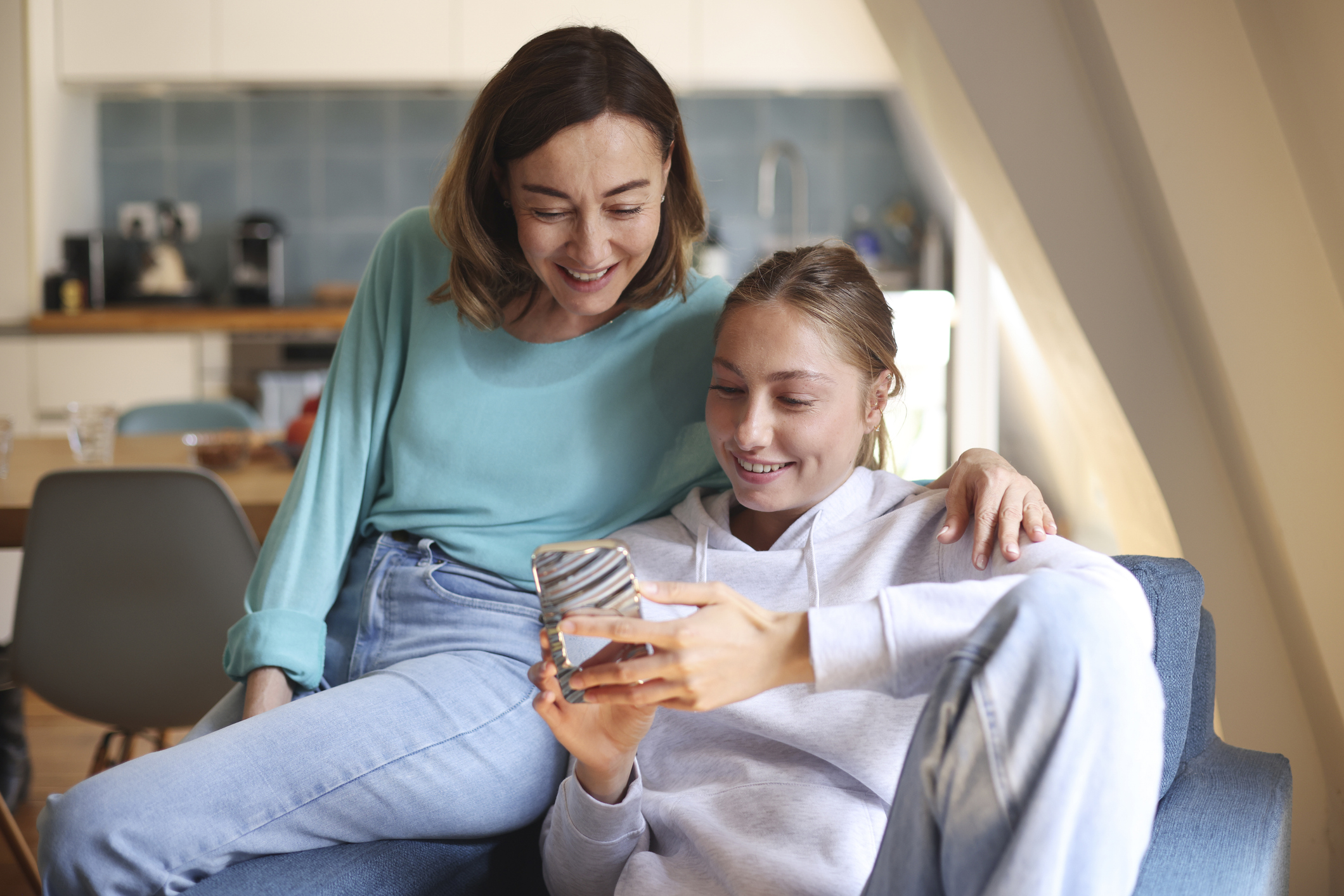 Teen sitting with mom applying for a checking account together at Magnifi Financial Credit Union.