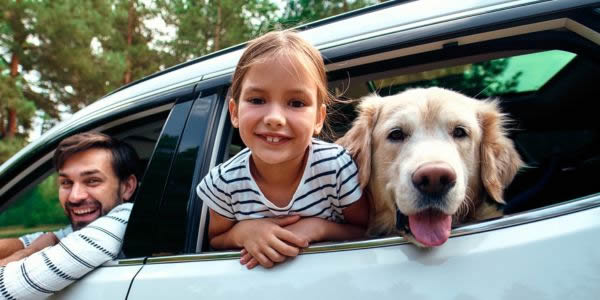 Family in a car with a dog