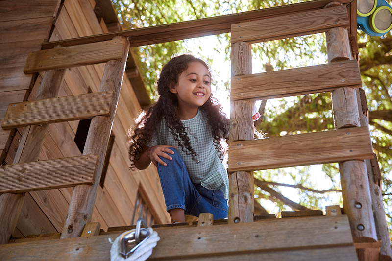 girl playing in tree house